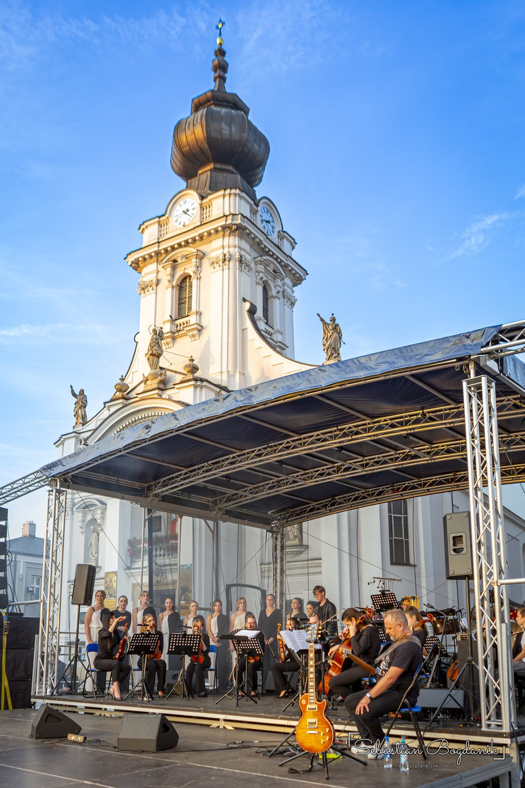 Przed koncertem: scena pod wieżą Bazyliki Ofiarowania NMP, orkiestra zajmuje miejsca.