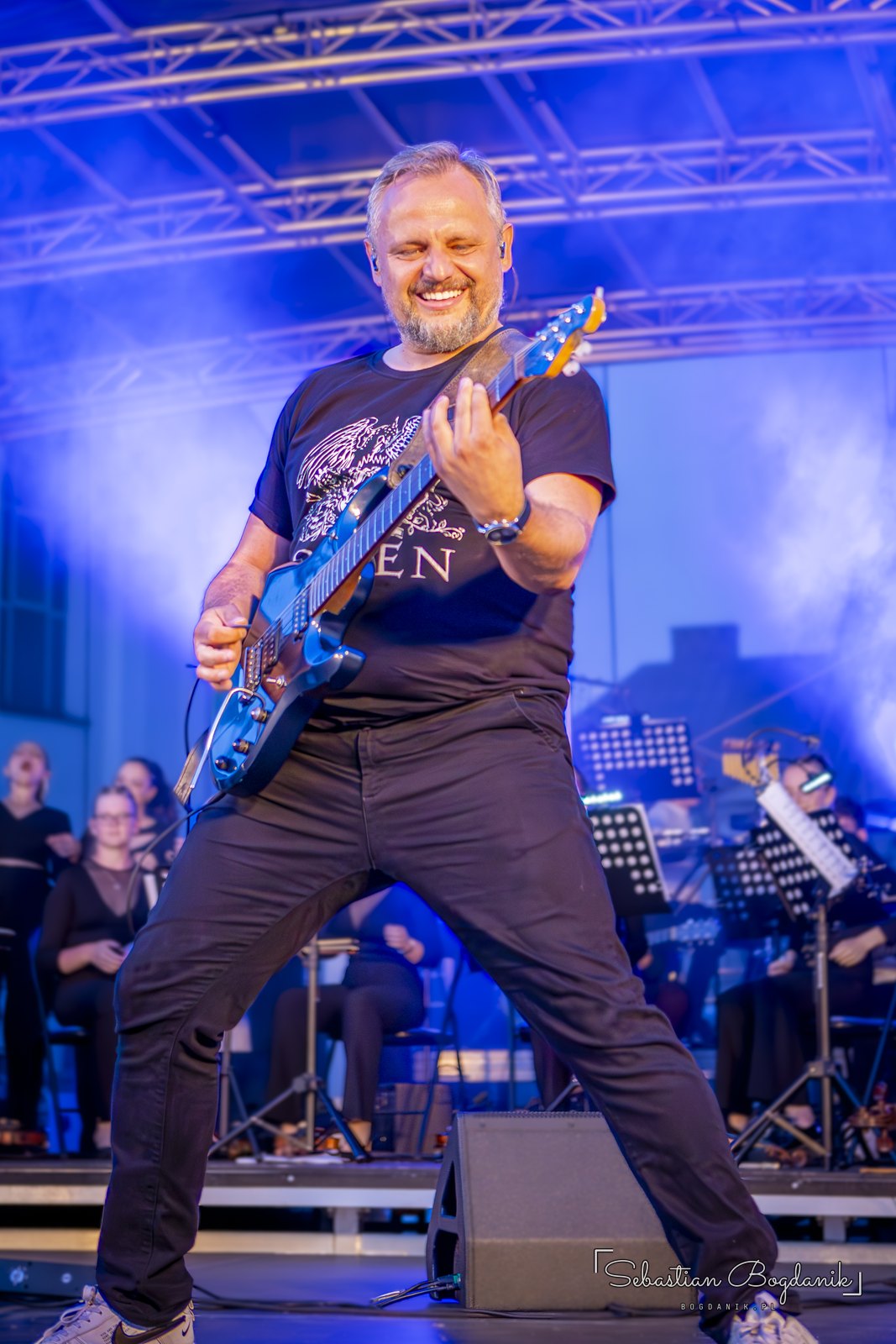 Gitara elektryczna w koszulce z napisem Queen.
