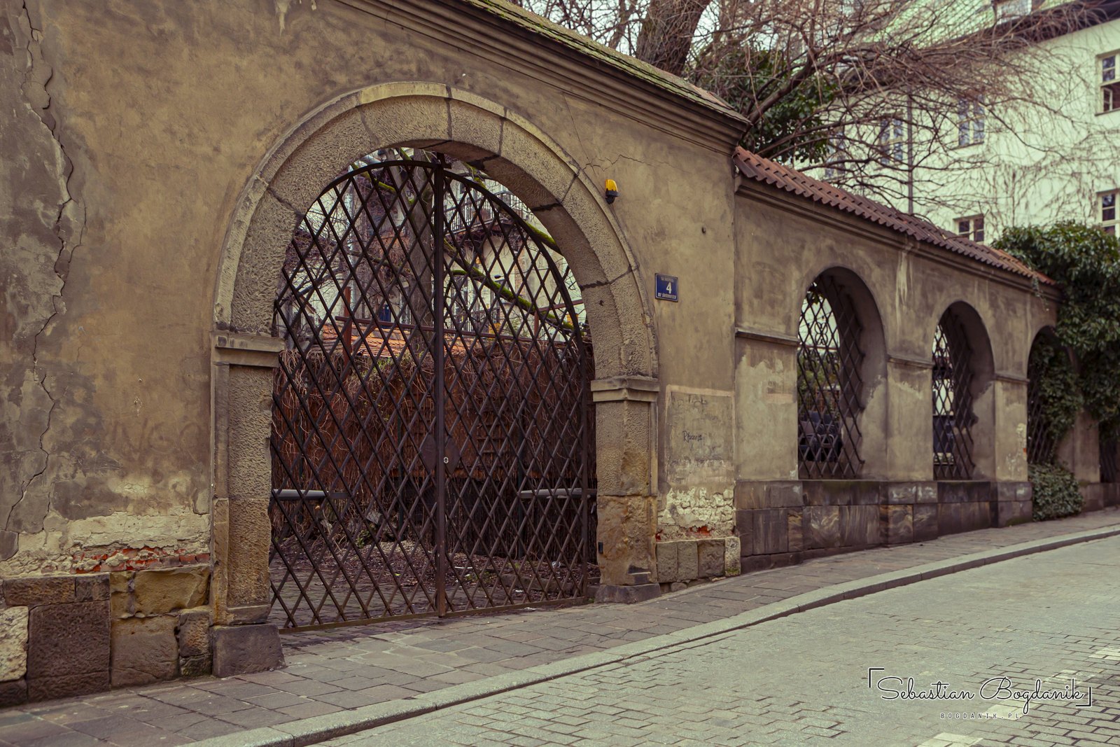 Świętego Krzyża Street: arcades and wrought-iron gates.