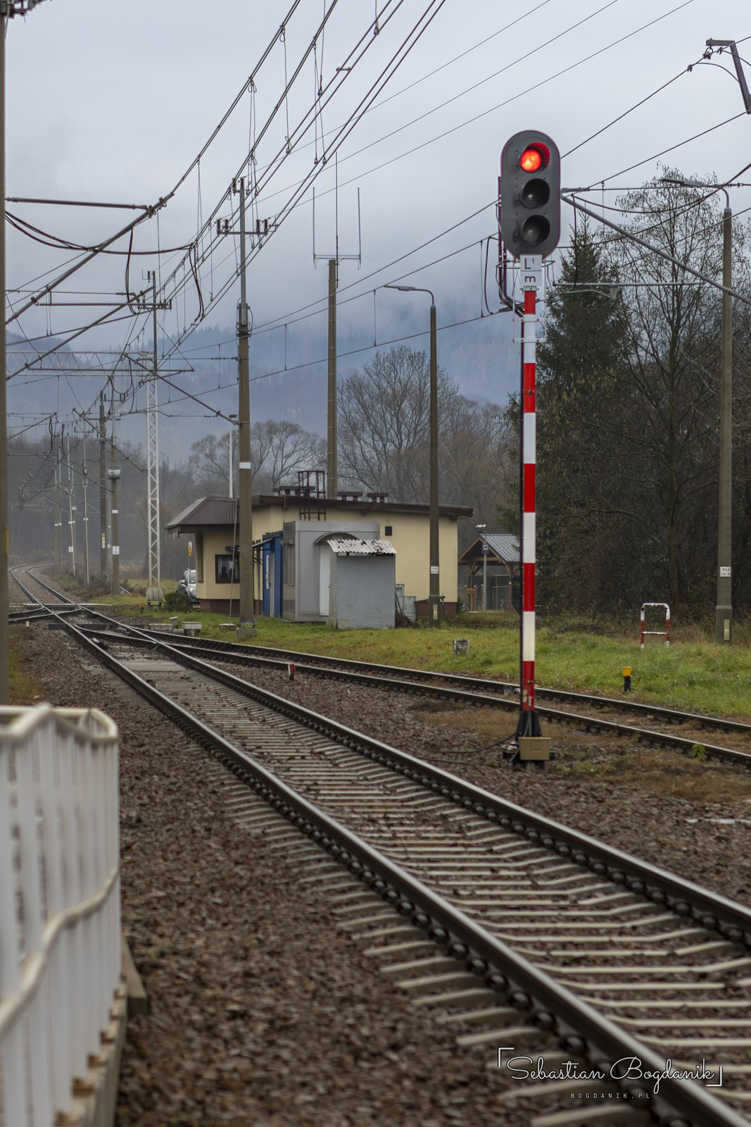Semafor przy torach. Nad Makowem wiszą niskie, listopadowe chmury.