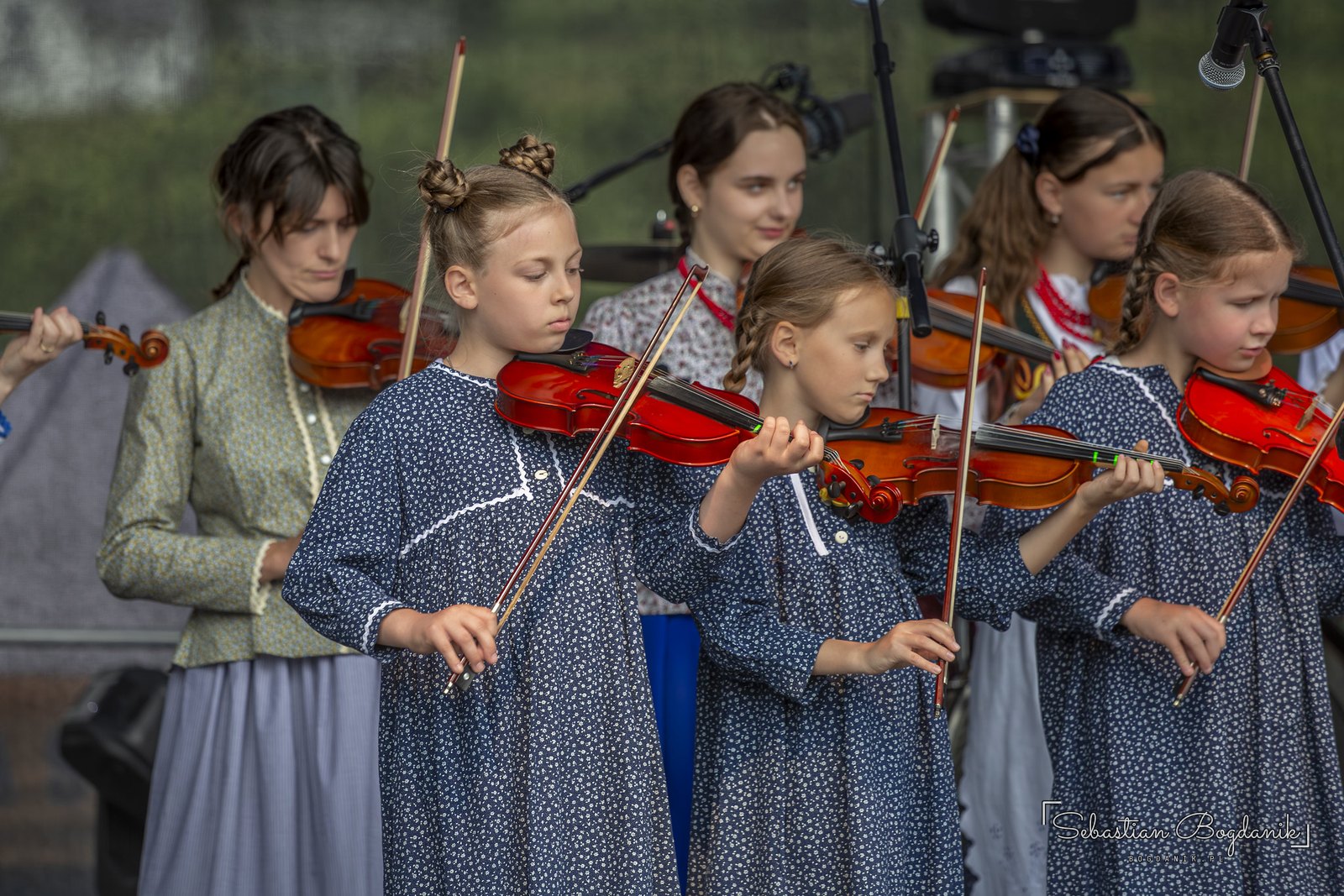 Young violinists in blue dresses.