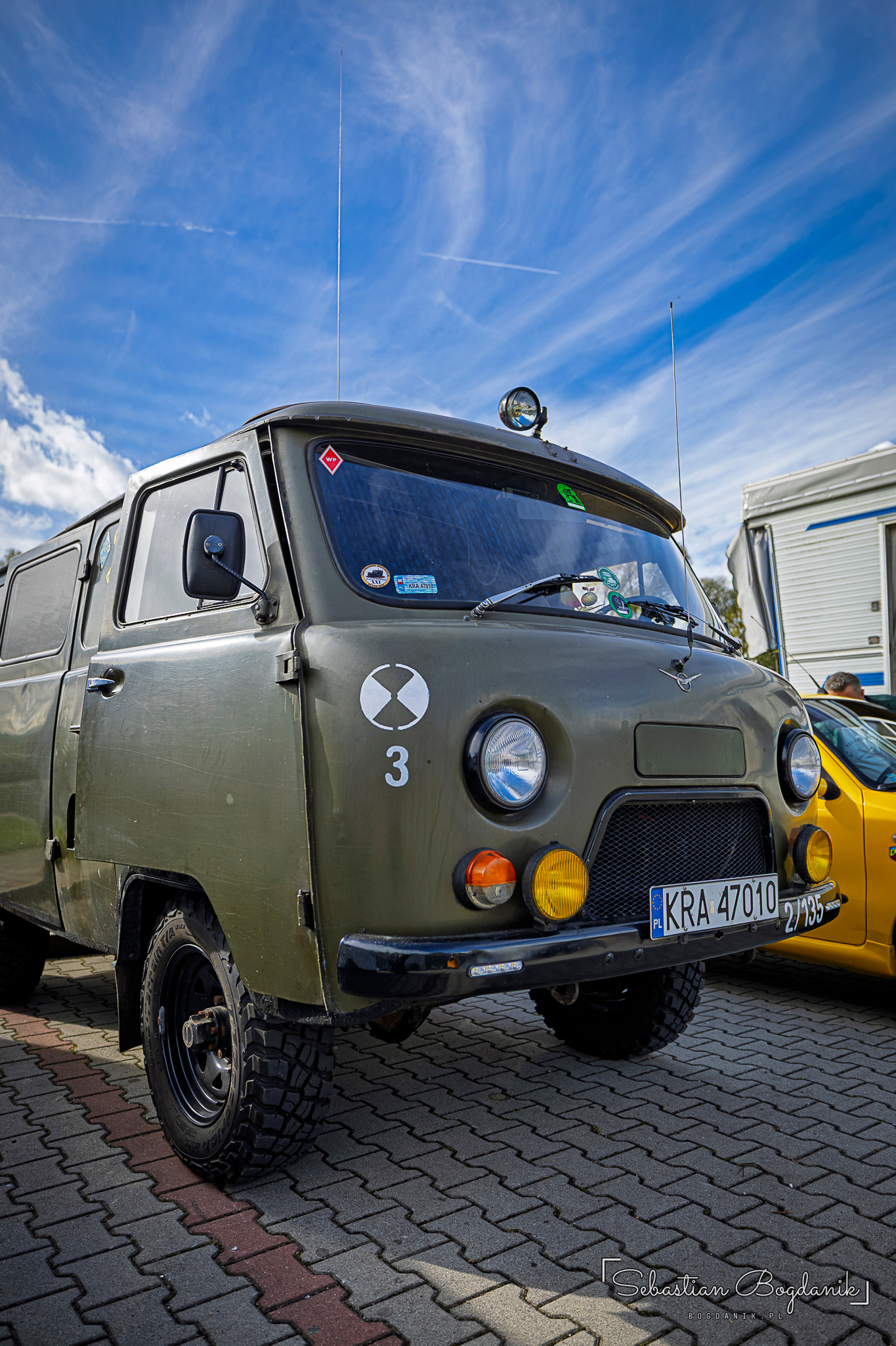 An olive green UAZ-452 with round headlights and a number on the front.