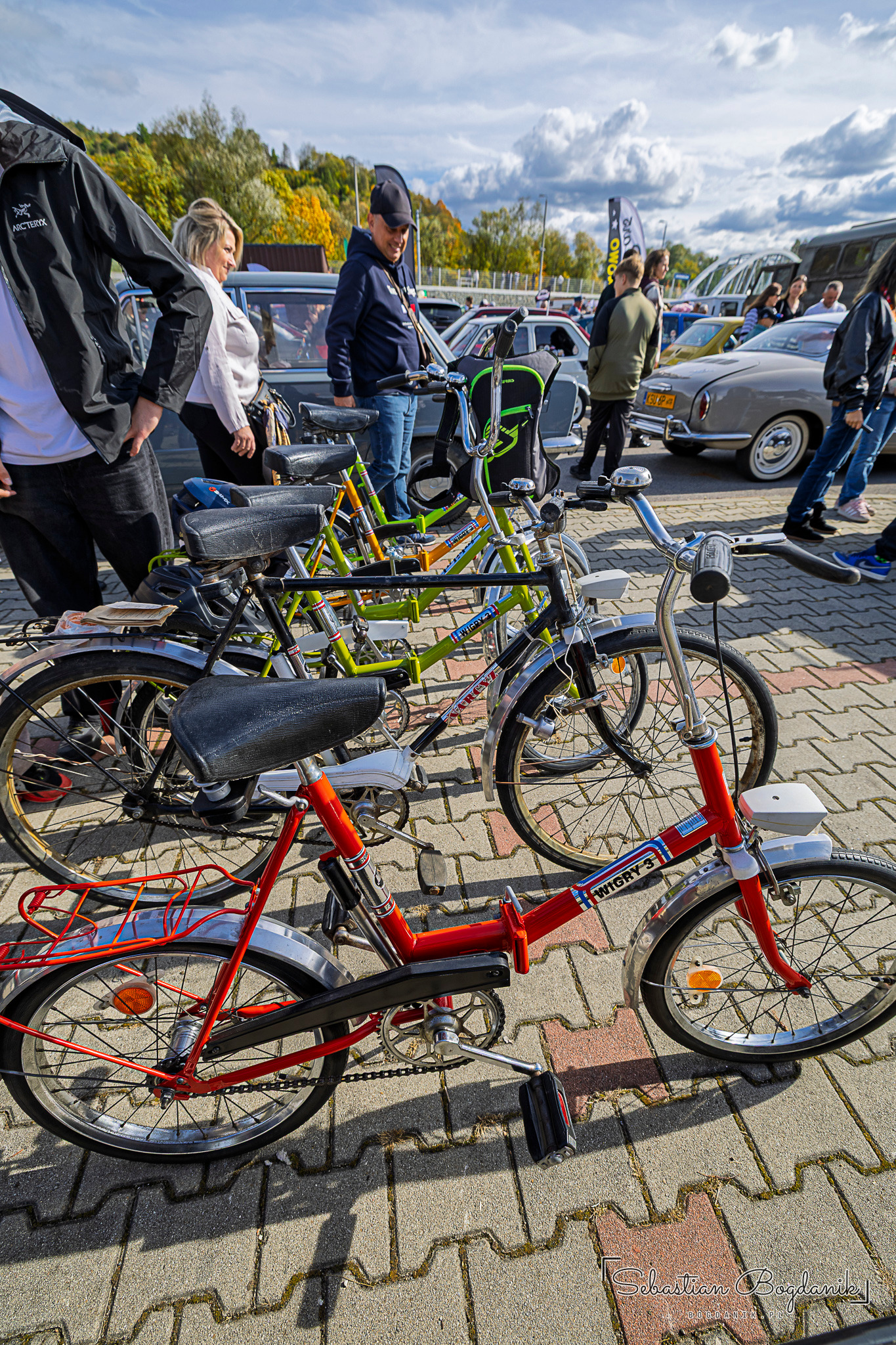 Several folding bicycles in different colours standing side by side on the square.